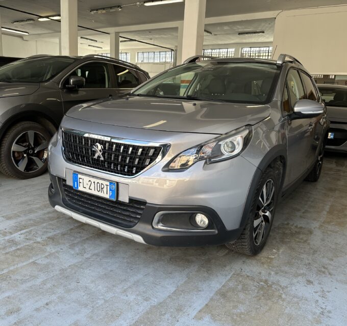 Grey Peugeot SUV in a car showroom with other vehicles and concrete pillars nearby