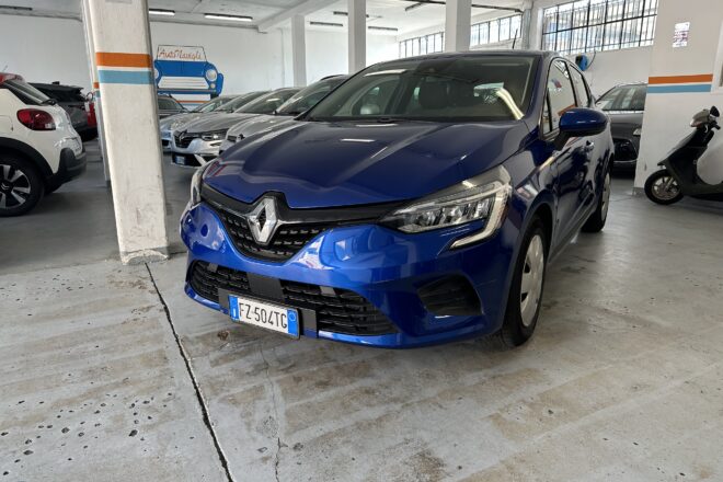 Blue Renault SUV parked in a dim indoor garage with other cars in a row and a scooter on the right edge of the frame.