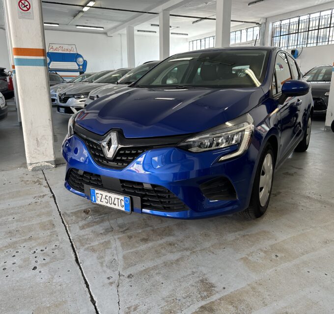 Blue Renault SUV parked in a dim indoor garage with other cars in a row and a scooter on the right edge of the frame.