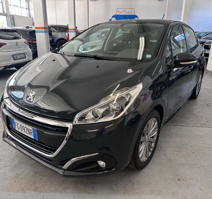 Front-left view of a shiny black Peugeot in an indoor car showroom with other cars in the background.