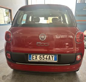 Red Fiat 500L seen from the rear in a garage, with license plate EX 63 ZAY visible