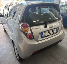 Rear view of a silver Chevrolet SUV parked in a garage, showing the tail lights and license plate.