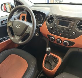 Interior of a car with orange and black seats, steering wheel, and center console gear lever visible.