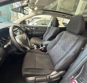 Interior of a car showing the steering wheel, driver and front passenger seats, and a large sunroof/panoramic roof visible above.