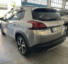 Silver Peugeot 2008 parked in a garage, rear three-quarter view with roof rails and alloy wheels visible.
