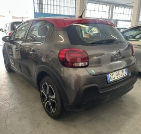 Rear three-quarter view of a gray Citroën SUV parked in a garage with other cars nearby.