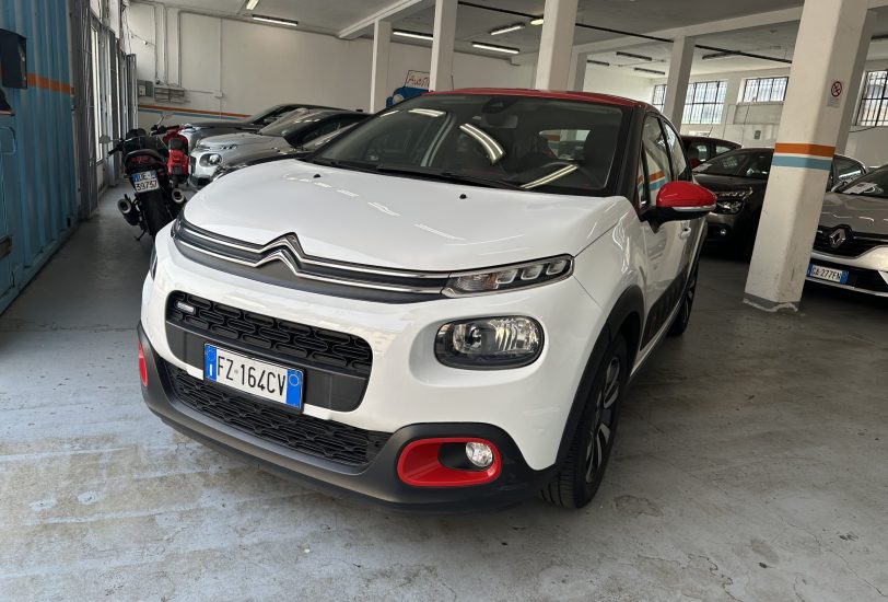 White Citroën SUV with red accents parked in an indoor garage, other cars lined up behind.