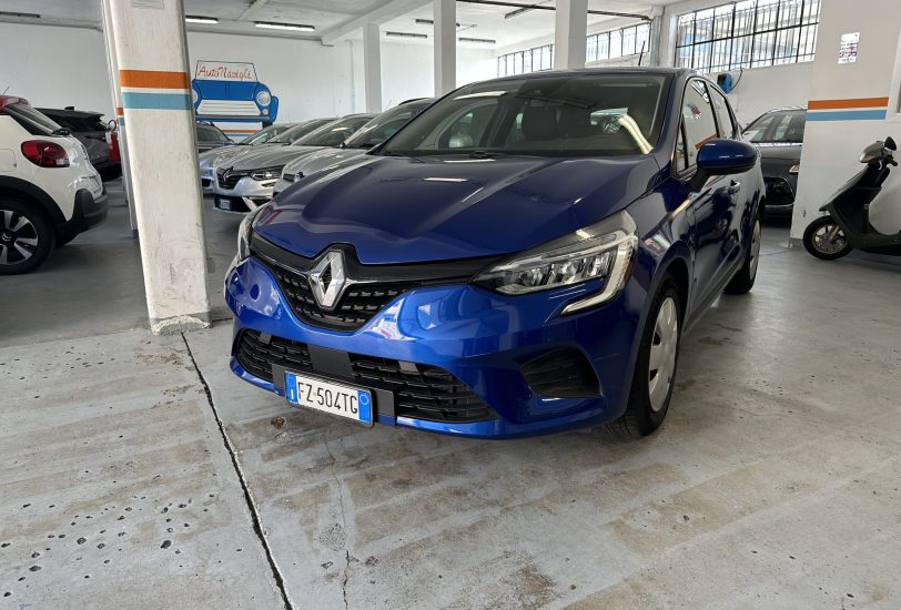 Blue Renault SUV parked in a dim indoor garage with other cars in a row and a scooter on the right edge of the frame.