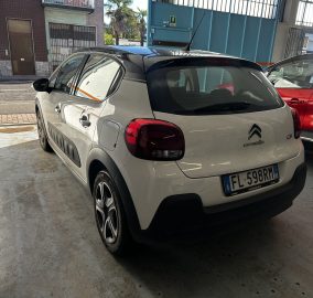 Rear three-quarter view of a white Citroën SUV parked in a garage beside a red car, license plate visible (EU plates).