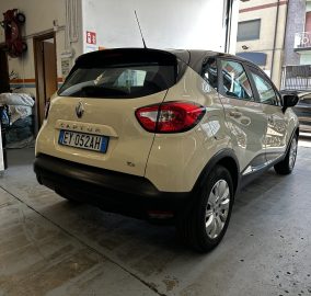 Beige Renault Captur SUV parked in a garage, seen from the rear with a European license plate EY-052AH and red taillights