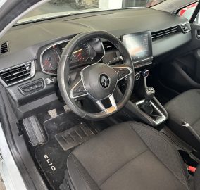Interior of a Renault car showing the steering wheel, gauge cluster, and a central touchscreen display on the dashboard.