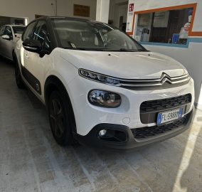 White Citroën van in a garage, shown from the front-right with another white car in the background.